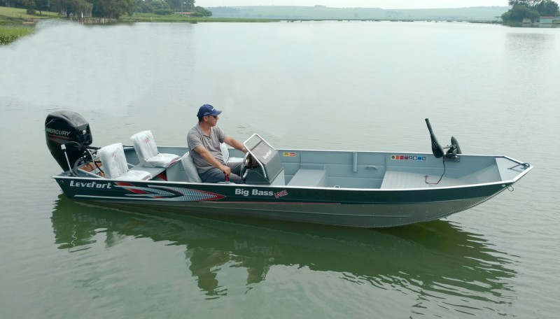Um homem sentado em um barco a pesca sentado em um lago