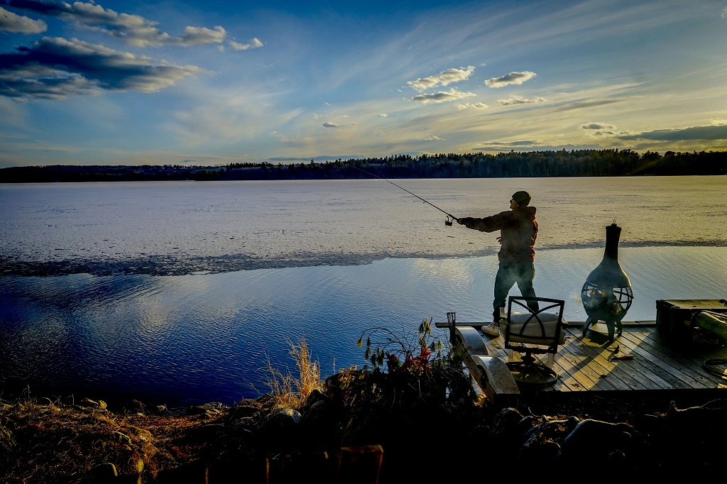 Um homem pescando na beira do rio.