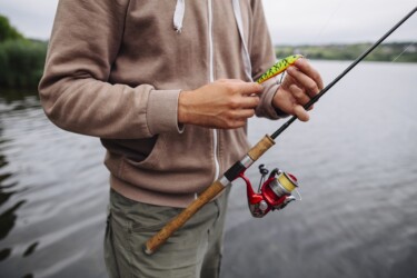 Um homem em um lago segura uma vara de pesca.