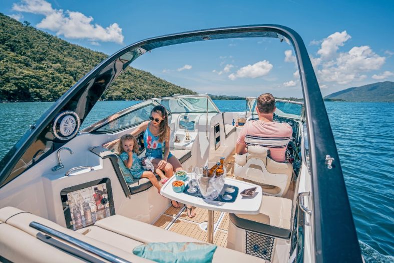 Família no cockpit da Focker 242 GTO com mesa, estofados claros e arco esportivo